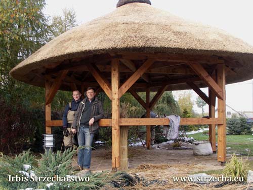 A hexagonal bower with a thatched roof and a heather ridge