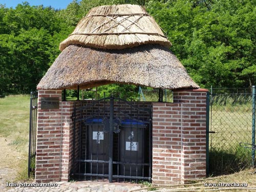 A roof of a stylish box housing garbage containers - a straw thatched roof with a straw ridge